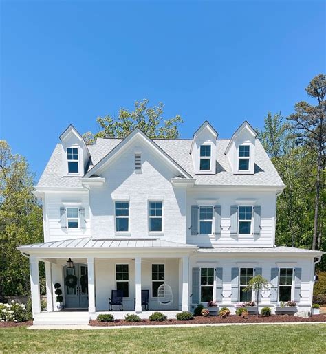 blue house white shutters metal roof|white house with blue roof.